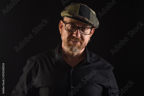 portrait of a man in low key,front view  with cap and eyewear