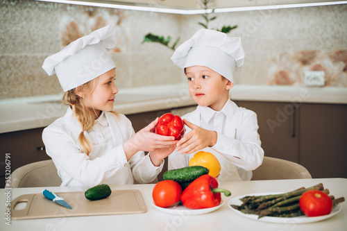 little cooks cut vegetables for salad