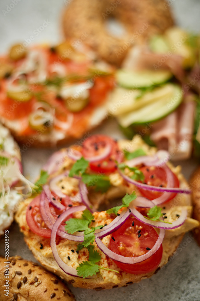 Assortment of different kinds toppings homemade bagels sandwiches with sesame and poppy seeds Assortment of different kinds toppings homemade bagels sandwiches with sesame and poppy seeds