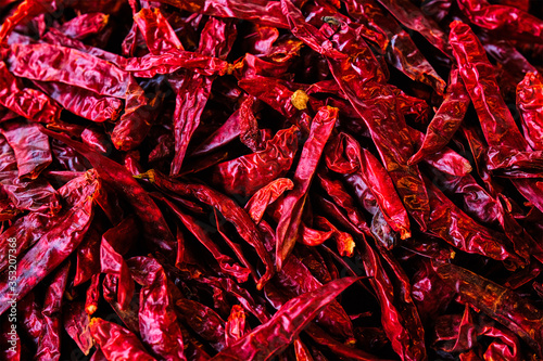 Dried dry red spicy chili peppers pile at asian market close up texture background. Sardar Market, Jodhpur, Rajasthan, India photo