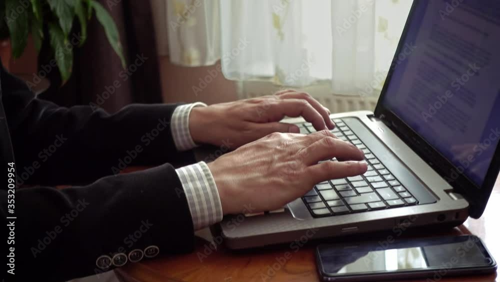 University professor working from home writing an essay using his laptop University professor working from home writing an essay using his laptop
