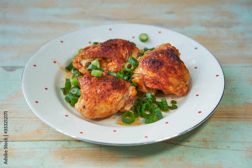 Close up Picture of vintage porcelain plate with roasted hot spicy chicken legs and chopped spring onion. Simple but tasty and juicy delicious light dish, with balanced nutritions and rich in protein.