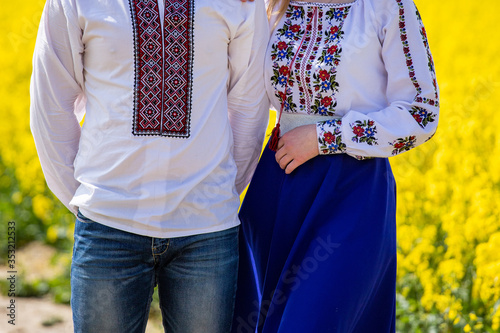 Ukrainian national clothing - embroideries. Girl and guy in embroidered shirts in a yellow field