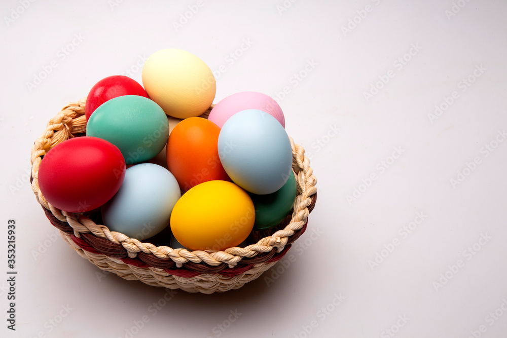 Multicolored Easter eggs in a basket on white background. Multicolored Easter eggs in a basket on white background.