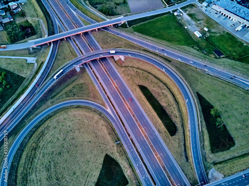 A beautiful panoramic aerial drone view of the sunset on the highway overpass of the southern Warsaw bypass (Polish: POW), Michalowice district in Warsaw, Opacz Kolonia, Poland photo