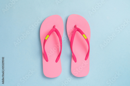 Pink sandals isolated on blue pastel background.