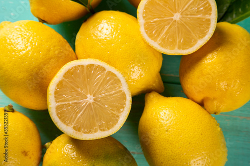 Yellow lemons on green wooden background