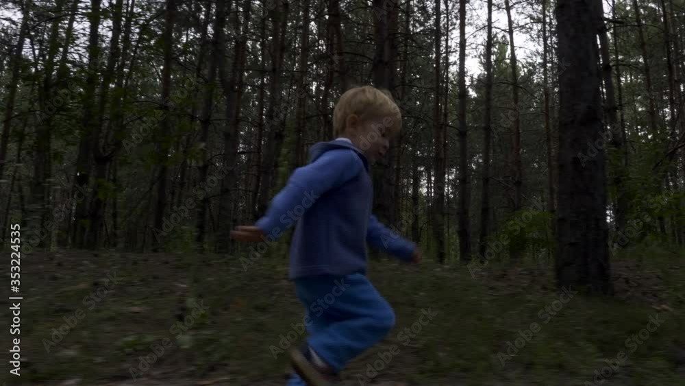 Little Boy Running Alone in the Forest. Lonely Child Wandering in the Wood. Summer Season Little Boy Running Alone in the Forest. Lonely Child Wandering in the Wood. Summer Season