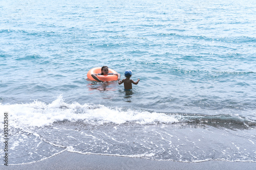 Happy family - sister and brotherl swim play with fun in the sea. Healthy lifestyle, active parent, people water outdoor adventure, swimming beach summer holidays with child.