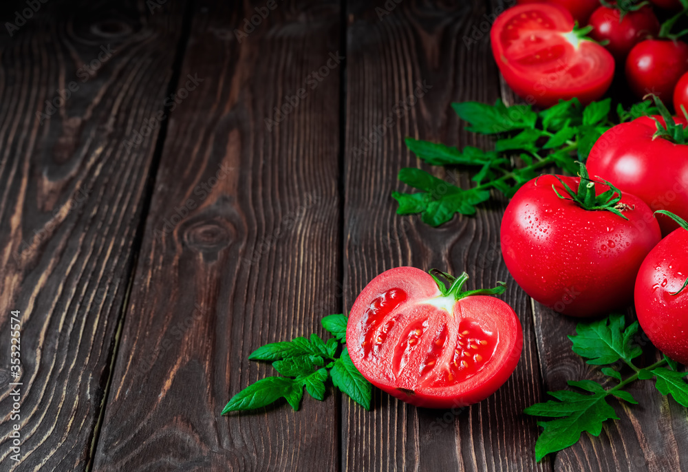 Slice of tomato and ripe red tomatoes close-up on a dark rustic background. Ripe vegetables from the market, ingredients for the preparation of salads or dishes. Copy space Slice of tomato and ripe red tomatoes close-up on a dark rustic background. Ripe vegetables from the market, ingredients for the preparation of salads or dishes. Copy space