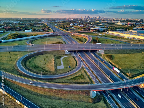 A beautiful panoramic aerial drone view of the sunset on the highway overpass of the southern Warsaw bypass (Polish: POW), Michalowice district in Warsaw, Opacz Kolonia, Poland