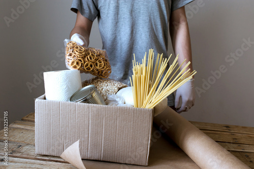 Продукты в картонной коробке, еда на карантине, необходимые продукты для изоляции, углеводи, продуктовий набор, человек складивает продукти в ящик, ящик с продуктами в руках