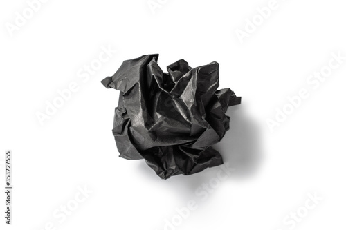 Black crumpled paper on a white background.