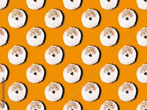 Wallpaper Mural Colourful dessert seamless pattern of donuts with white icing and multicolored sugar pastry topping on orange background. Top view Torontodigital.ca
