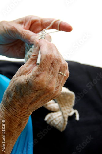 Mãos de senhora idosa tricotando