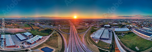 A beautiful panoramic aerial drone view of the sunset on the highway overpass of the southern Warsaw bypass (Polish: POW), Michalowice district in Warsaw, Opacz Kolonia, Poland photo