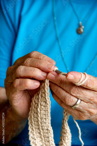Mãos de senhora idosa tricotando