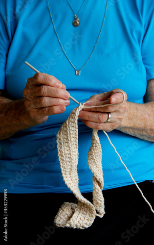Mãos de senhora idosa tricotando