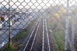 fence net behind which rail. Railway rails going into the distance