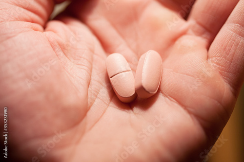 Two pink pills in arm. Macro image.