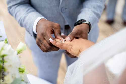 Photographie Bride and groom exchanging wedding rings close up during symbolic nautical decor