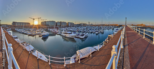 Panoramic image of Elizabeth Marina, St Helier early morning from the West marina wall with the entrance and Elizabeth Castle on the right hand side of the image. Jersey, Channel Islands, UK