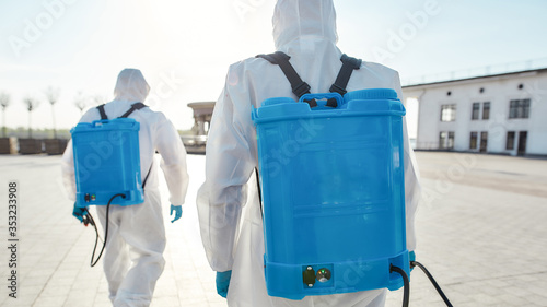 Save Lives. Sanitization and cleaning of the city due to the emergence of the Covid19 virus. Specialized team in protective suits and masks with backpack of pressurized spray disinfectant