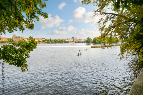 Photography Tourists and local Czechs kayak near the falls on the Vltava River in Prague, Czech Republic on a summer afternoon