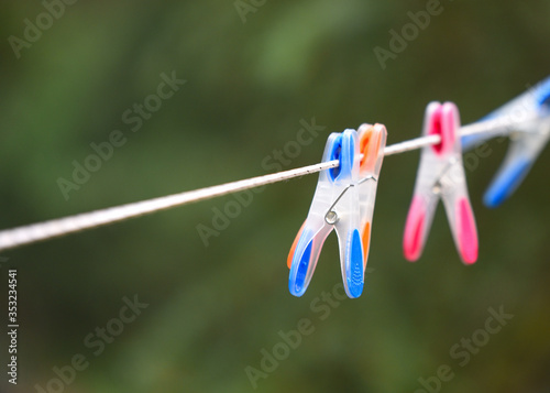 Bright coloured pins on clothes line closeup in forest with empty space
