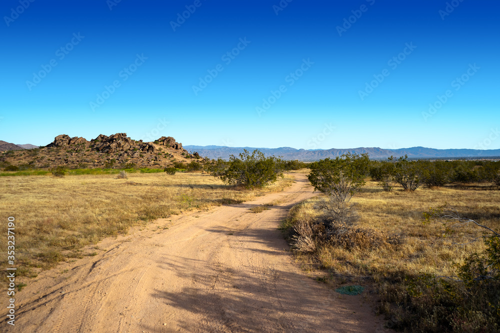 Empty dirt road with a rock hill formation in the Mojave Desert Town of Apple Valley