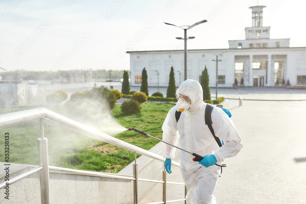 For health and environment. Sanitization, cleaning, disinfection of the streets and alleys in the city center due to the emergence of the Covid19 virus. Man in protective suit and mask at work
