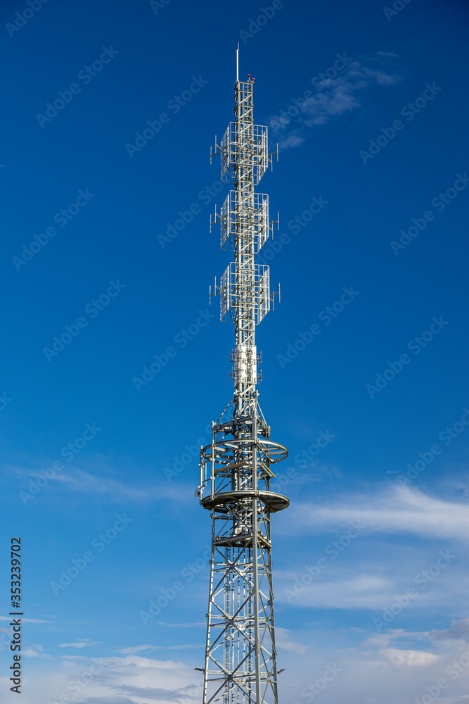 Wieża radiowa na tle niebieskiego nieba.
