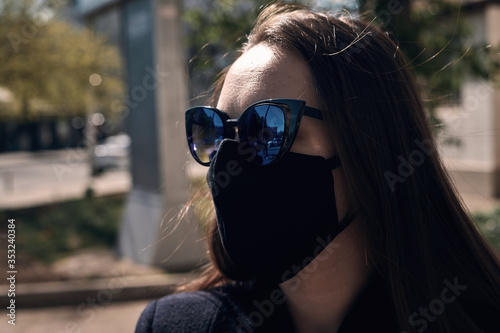 masked girl against coronavirus walking the streets of the city