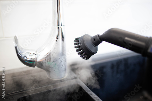 cleaning the sink and faucet with a steam cleaner, disinfection in the house. photo