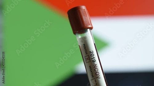 Corona virus or Covid-19 in Sudan , sample blood tube with Sudan flag on background