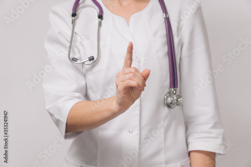 woman doctor on a light background. Concept female hands show attention sign.