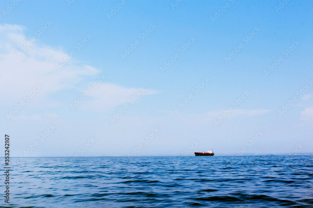 Seascape with a faraway cargo ship