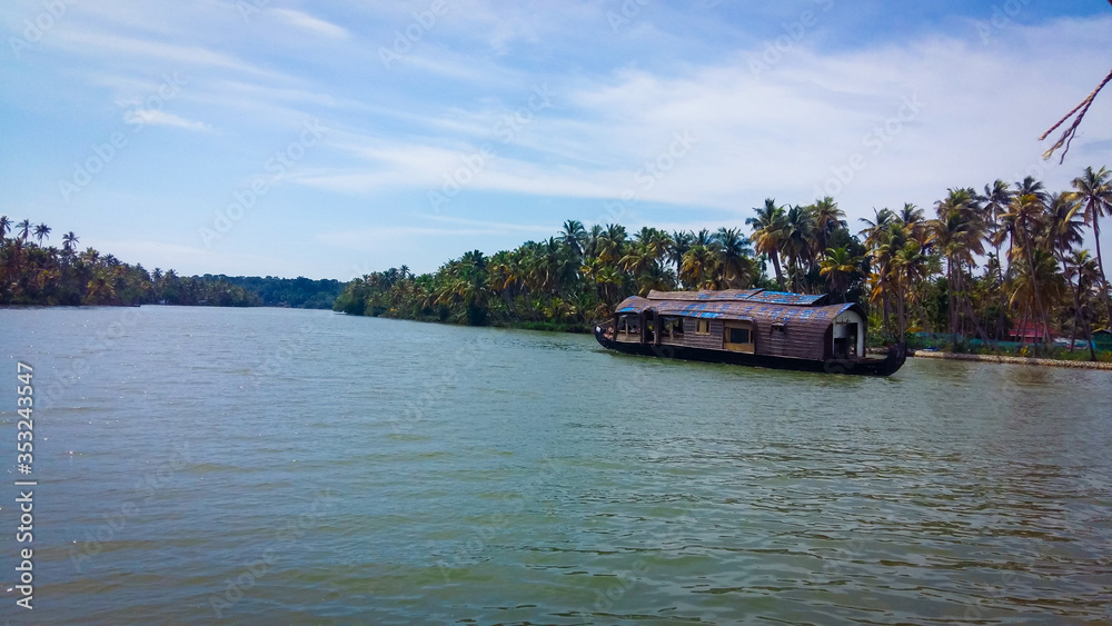 A houseboat sailing in Ashtamudi Lake in Kerala. Kerala Backwaters.