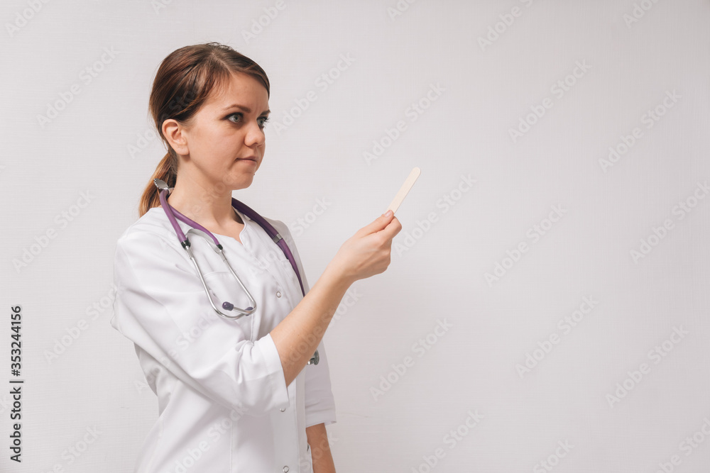 Young beautiful female ENT doctor . Concept female hands show disposable spatula