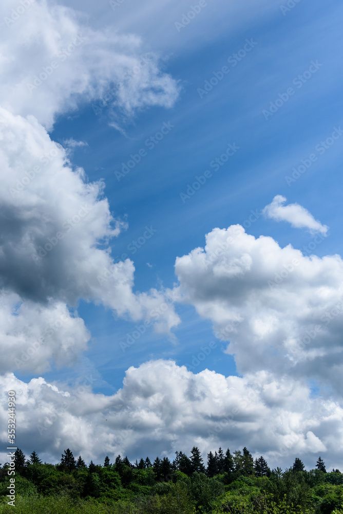 Blue sky with white cloud streaks and ominous gray and white clouds as a nature background
