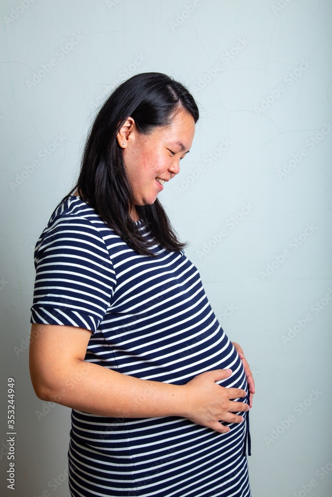 Happy Asia Chinese Pregnant women pregnant in 36 Weeks with holding hands on her belly Happy Asia Chinese Pregnant women pregnant in 36 Weeks with holding hands on her belly