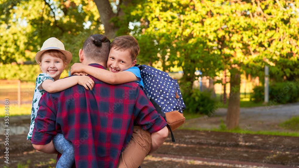 Fototapeta premium happy family of father and children.The father holds the children in his arms