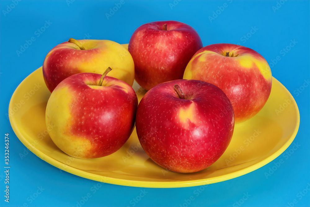 Close up of ripe red apples in a bowl on blue background. Close up of ripe red apples in a bowl on blue background.