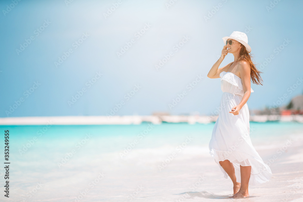 Young beautiful woman having fun on tropical seashore. Happy girl background the blue sky and turquoise water in the sea Young beautiful woman having fun on tropical seashore. Happy girl background the blue sky and turquoise water in the sea