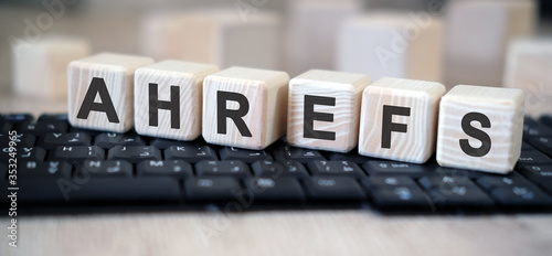 Ahrefs - text cubes stand on a black keyboard on a wooden table