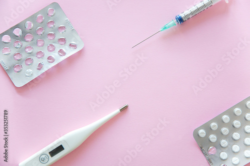 Medical concept. Protective measures against coronavirus. Viruses and protection from them. Flat lay. Tablets, thermometer and bondages on blue background. Copy space. photo