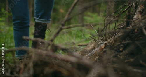 Wallpaper Mural A woman on a trip to the forest ties her shoelaces. Hiking boots in the forest Torontodigital.ca