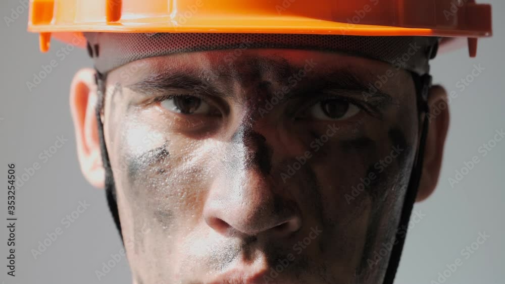 Portrait Dirty Mine Worker. Beautiful Caucasian Man in a Hard Hat. Filthy Job and Physical labor. Coal mining. People Working Equipment. Looking at Camera. Close up Portrait Dirty Mine Worker. Beautiful Caucasian Man in a Hard Hat. Filthy Job and Physical labor. Coal mining. People Working Equipment. Looking at Camera. Close up