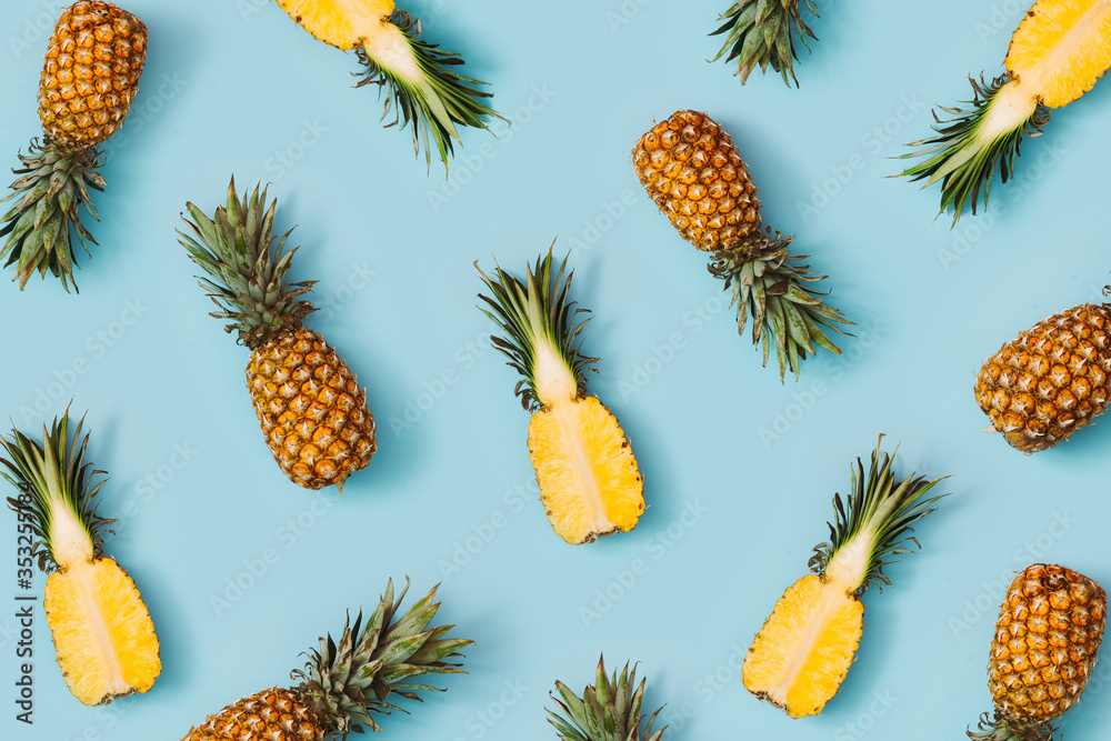 Colorful pattern of pineapples on pastel blue background. Top view. Minimal tropical fruit summer concept. Colorful pattern of pineapples on pastel blue background. Top view. Minimal tropical fruit summer concept.