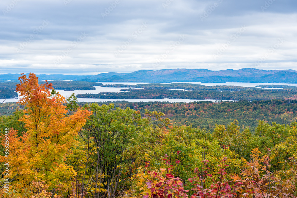 Magnificent forested mountain landscape dotted with lakes on an overcast autum day. Stunning fall colors. Lakes Region, NH, USA.